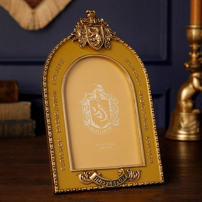 Golden arched photo frame with Hufflepuff crest and decorative scrollwork