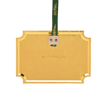 Back of gold metal ornament with gray hanging loop and green ribbon.