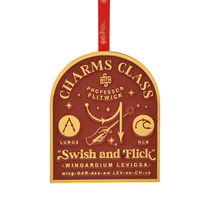 Round metal hanging charm with brown crest, gold lettering and red hanging ribbon