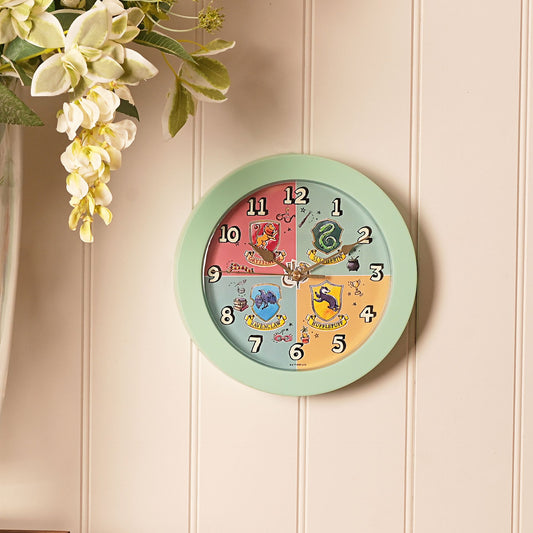 Mint green wall clock with house-crests dial, hanging charm, and numbered face
