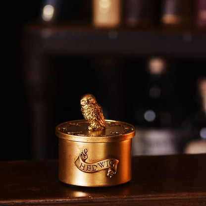 Gold Hedwig trinket pot with owl figurine on open lid and engraved front