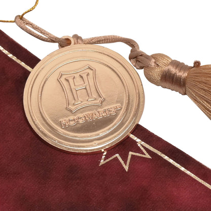 Gryffindor hanging banner close-up of round gold charm with tassel on maroon fabric