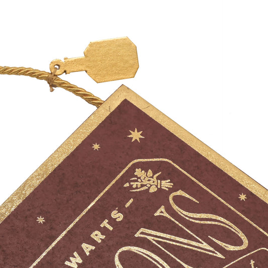 Maroon Hogwarts potion pendant corner with gold text and star emblem, tied tassel
