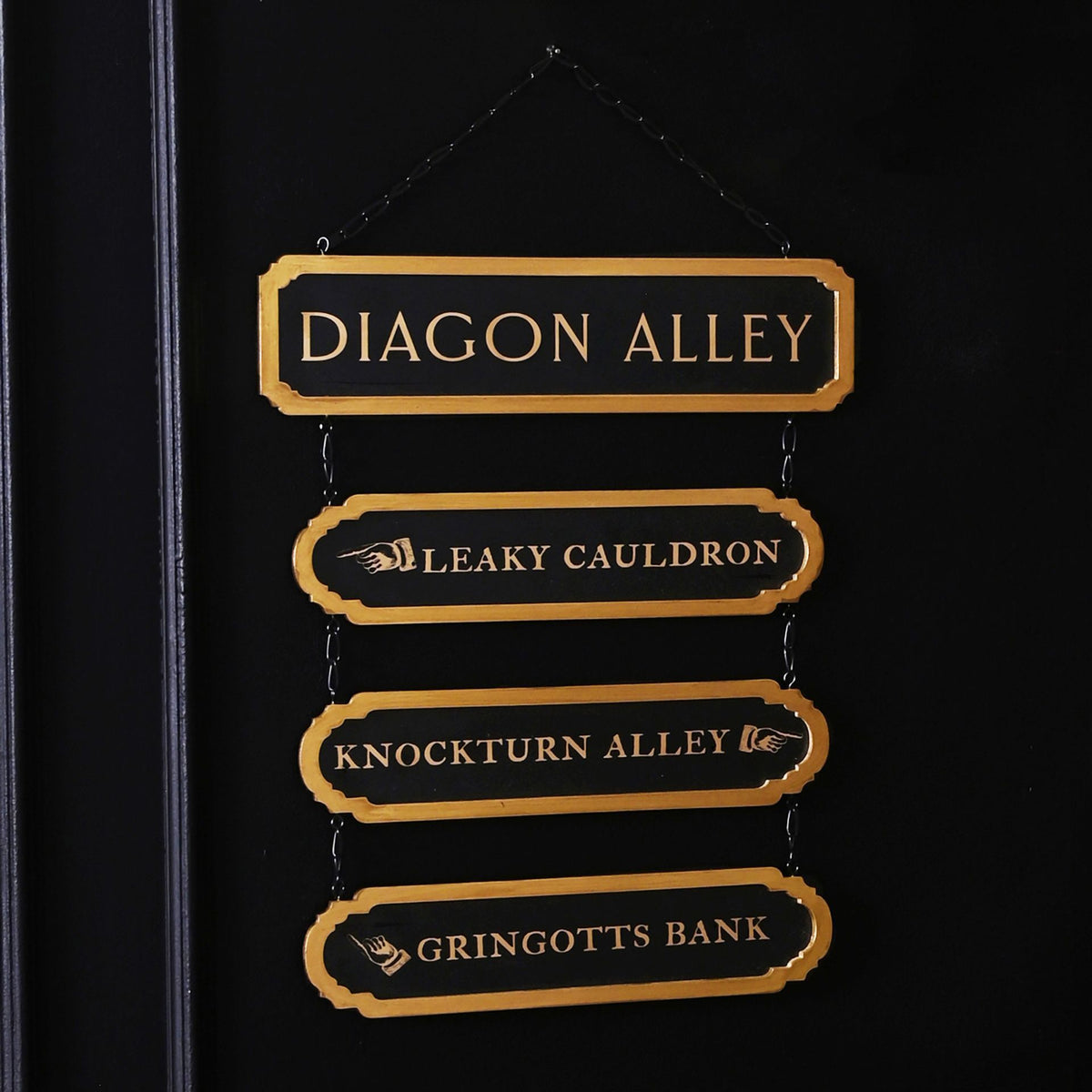 Gold-lettered hanging wooden signs: Diagon Alley, Leaky Cauldron, Knockturn Alley, Gringotts