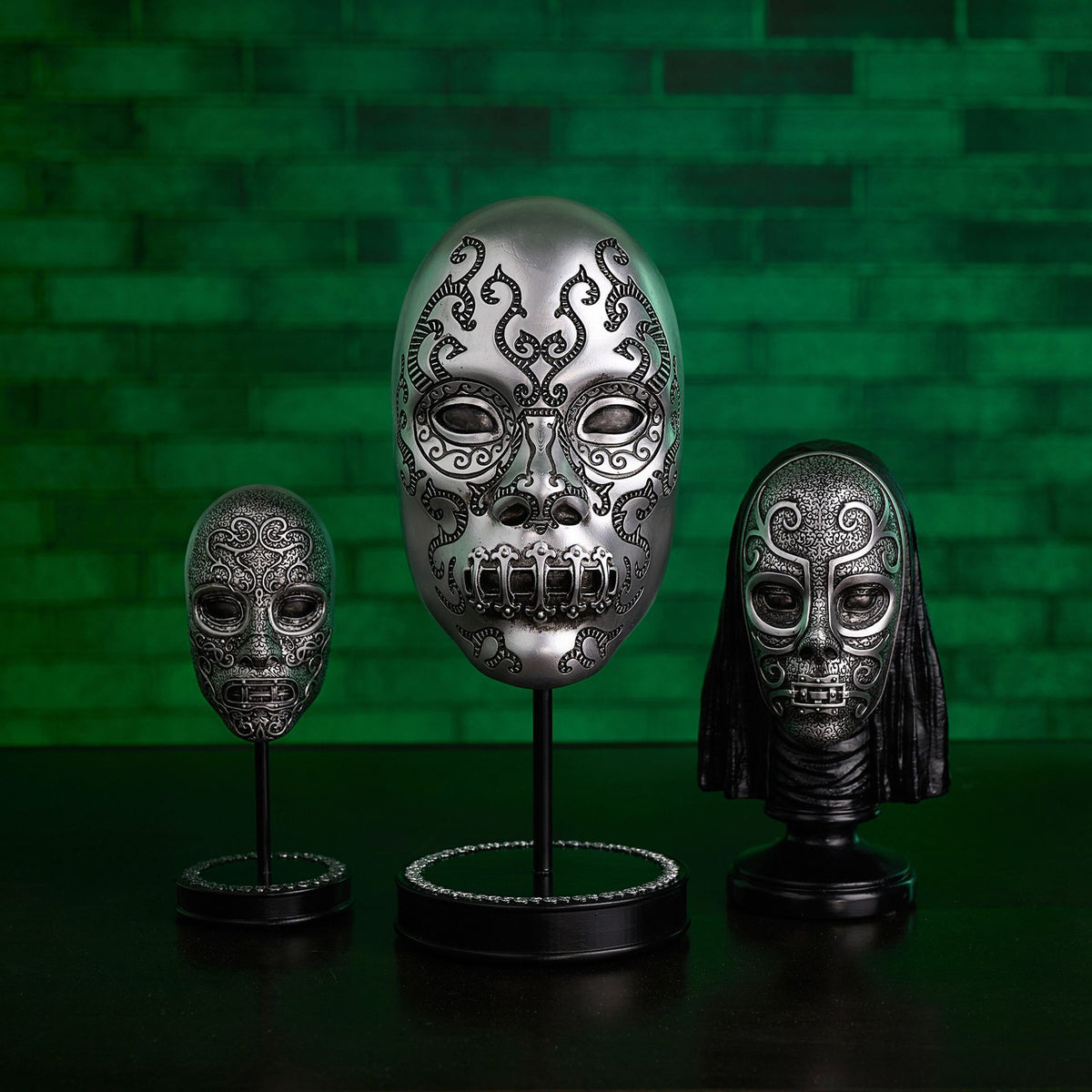 Death Eater bust figurine with silver skull mask and black hood on display stand