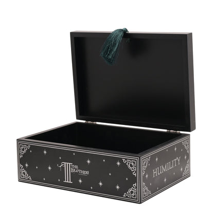 Open black box with teal tassel pull and star-pattern “Humility” side text