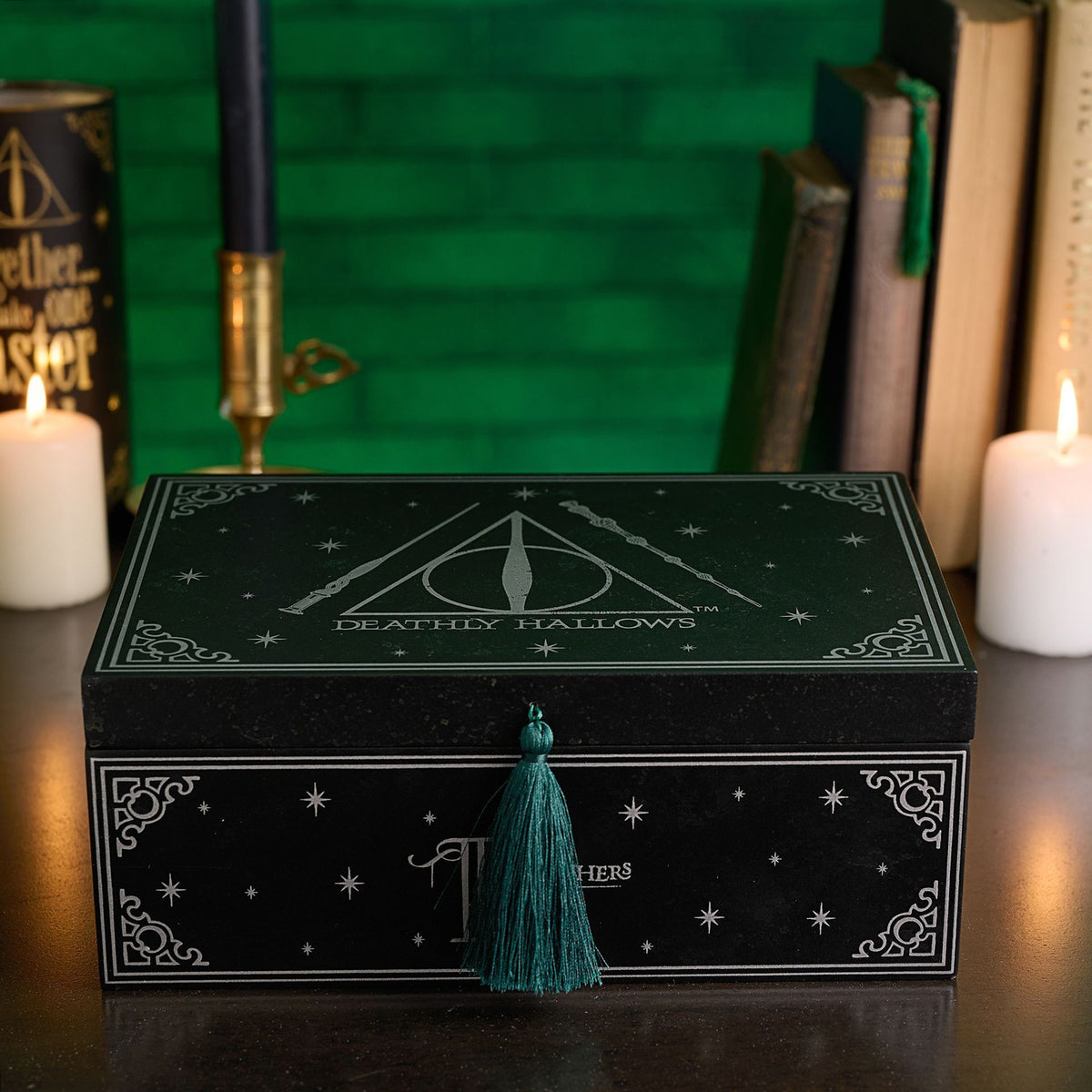Black “Deathly Hallows” storage box with teal tassel on front, shown with lid on