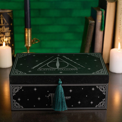 Black “Deathly Hallows” storage box with teal tassel on front, shown with lid on
