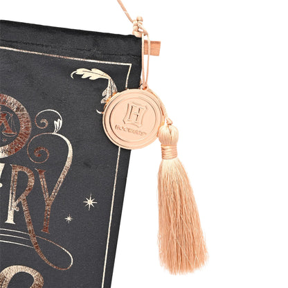 Black banner edge with circular crest medallion and peach tassel