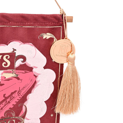 Maroon banner detail with Hogwarts crest medallion and gold tassel