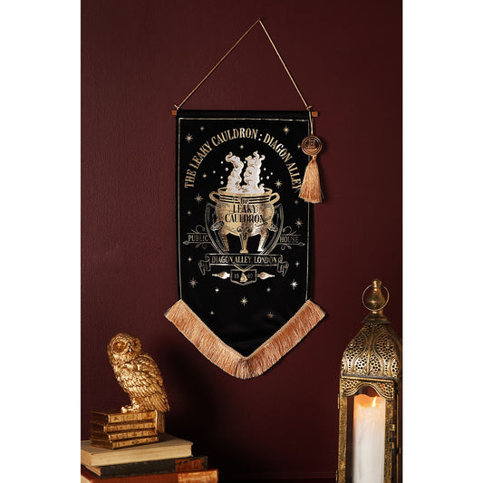 Black hanging banner with gold cauldron crest, star icons, tan fringe and tassel