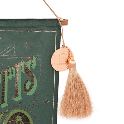 Green banner edge with tan tassel and circular emblem charm detail