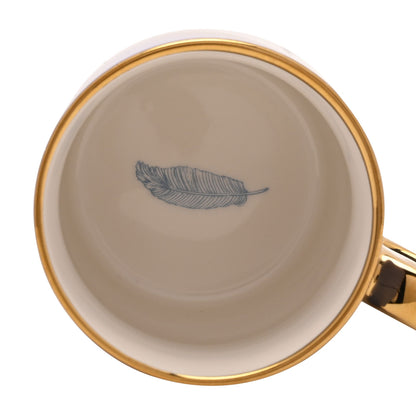 Blue ceramic mug bottom with gold rim and blue feather design.