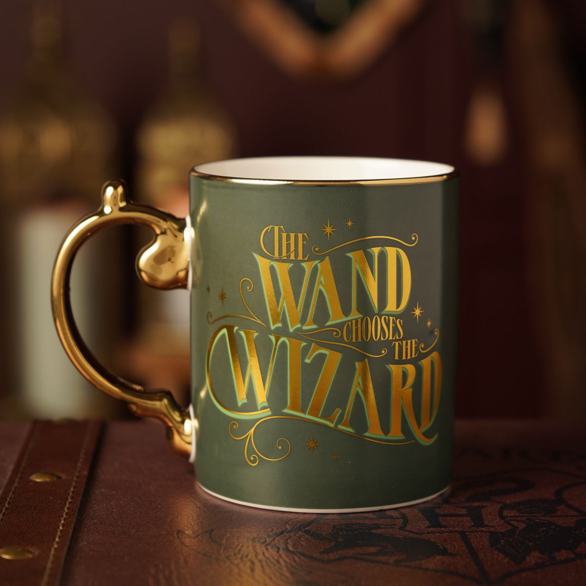 Collectible mug with “The wand chooses the wizard” gold text and curved gold handle