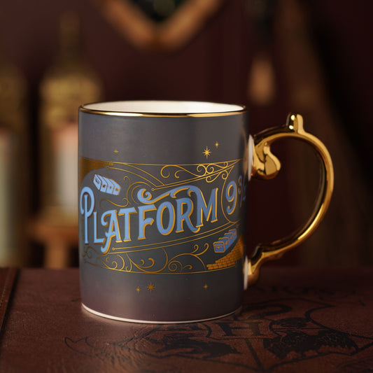 Dark gray collectible mug with gold handle and Platform 9 3/4 logo on front.