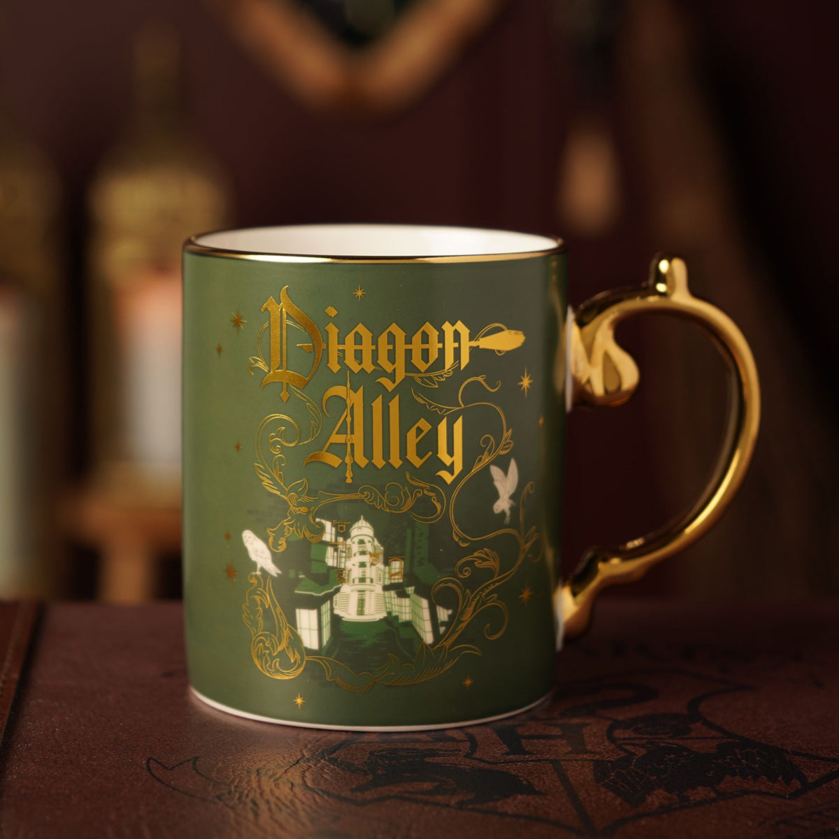 Green ceramic mug with gold handle, Diagon Alley graphic and lettering on front