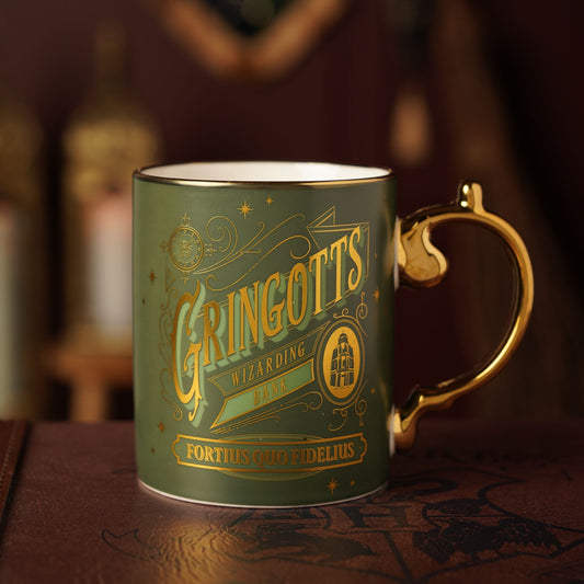 Green collectible mug with gold Gringotts graphic, wizarding bank text, and motto