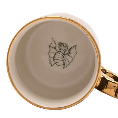 Interior of collectible mug with white finish, gold rim, and small dragon emblem