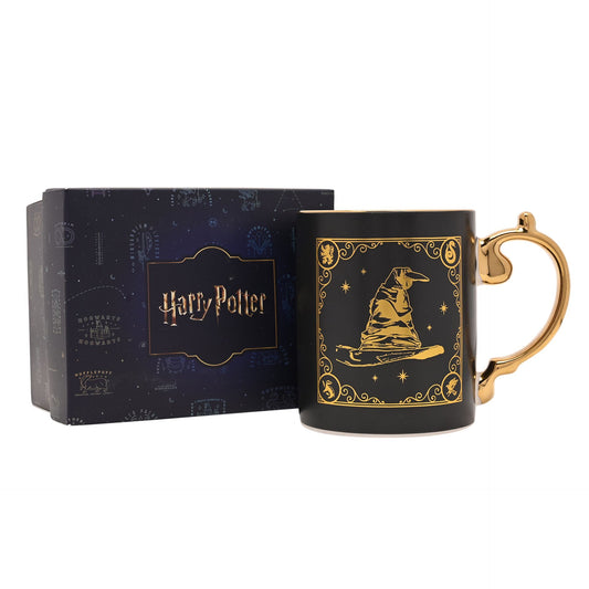 Black collectible mug with gold wizard scene, gold loop handle, white interior; shown with box