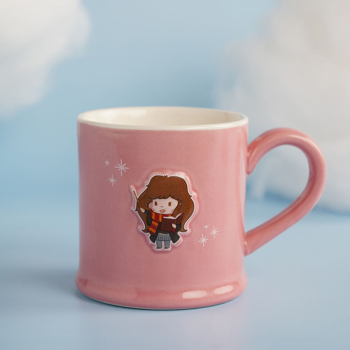 Pink ceramic mug with embossed Hermione-style character and star accents, side view