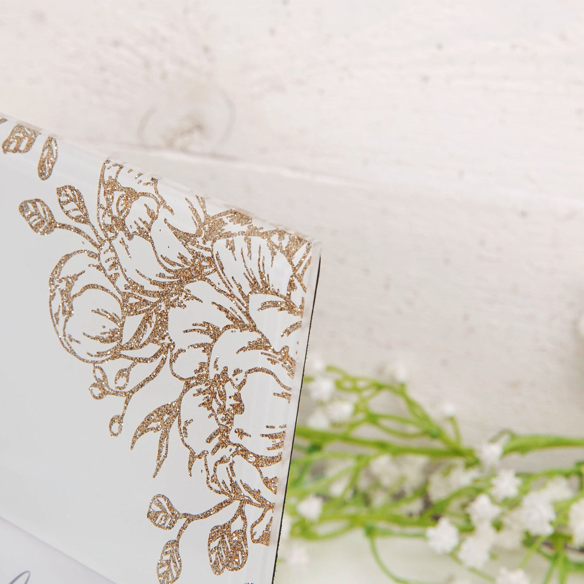 Close-up of gold floral print on pale grey 6x4 photo frame corner