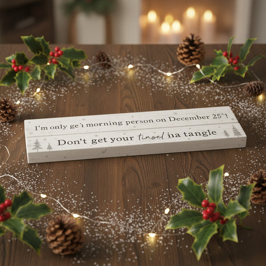 Two  white wooden signs with black printed Christmas-themed humorous quote.