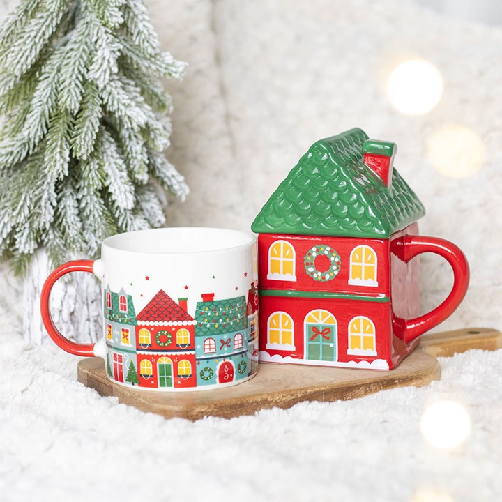 Christmas town print mug with red handle beside green house-shaped lid