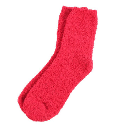 Pair of red fuzzy Christmas socks, plush knit style.