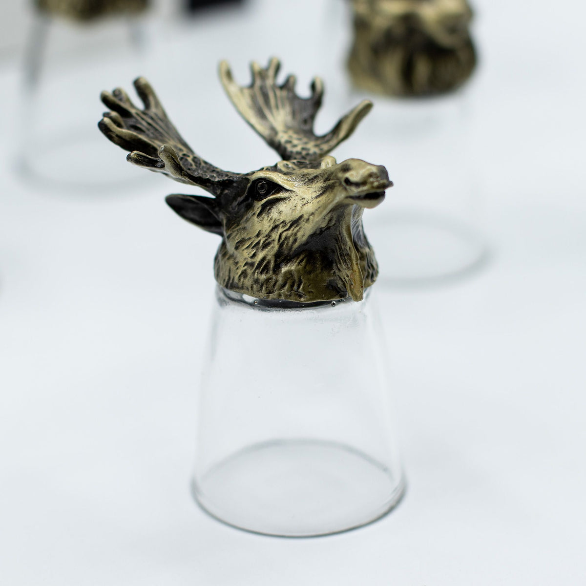 Antique bronze antlered deer bottom-up shot glass, clear glass base