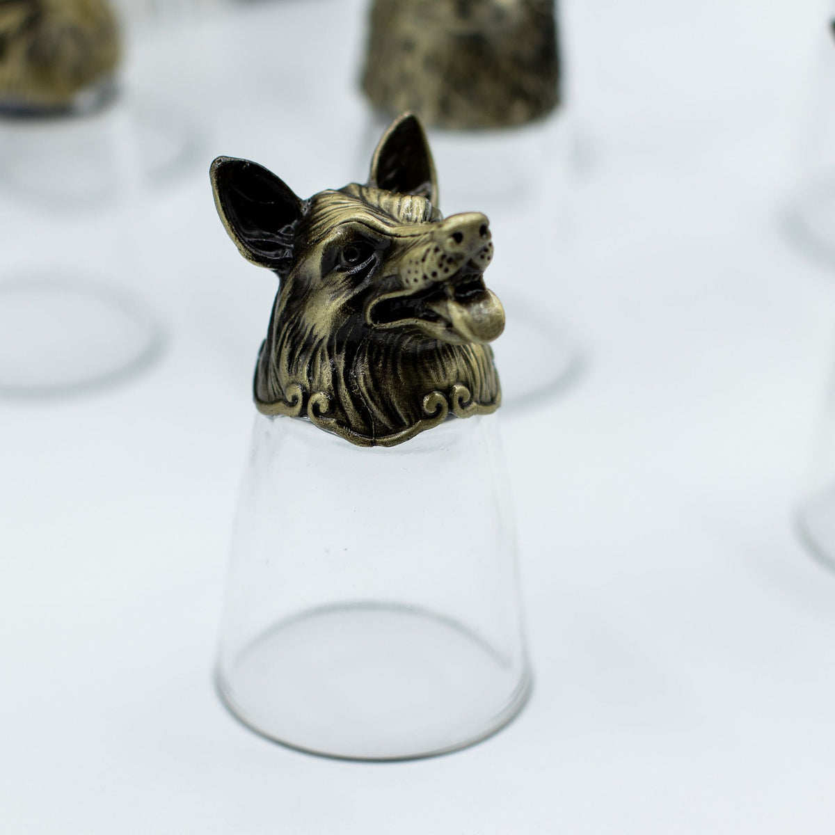 Clear shot glass with antique bronze cat-like creature topper, centered