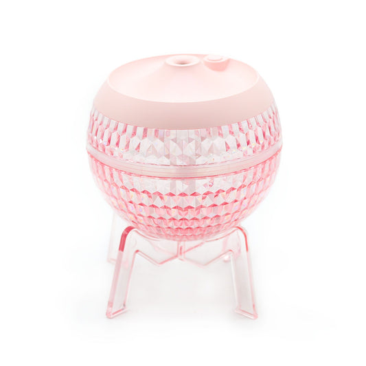Pink planet humidifier with faceted sides and rounded top, on three clear legs