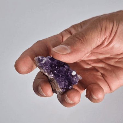 Close-up of natural amethyst cluster, deep purple crystals on tan matrix