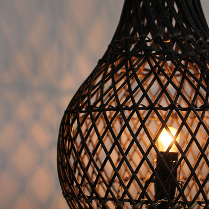 Black rattan lamp shade lattice with warm light glow seen through the weave