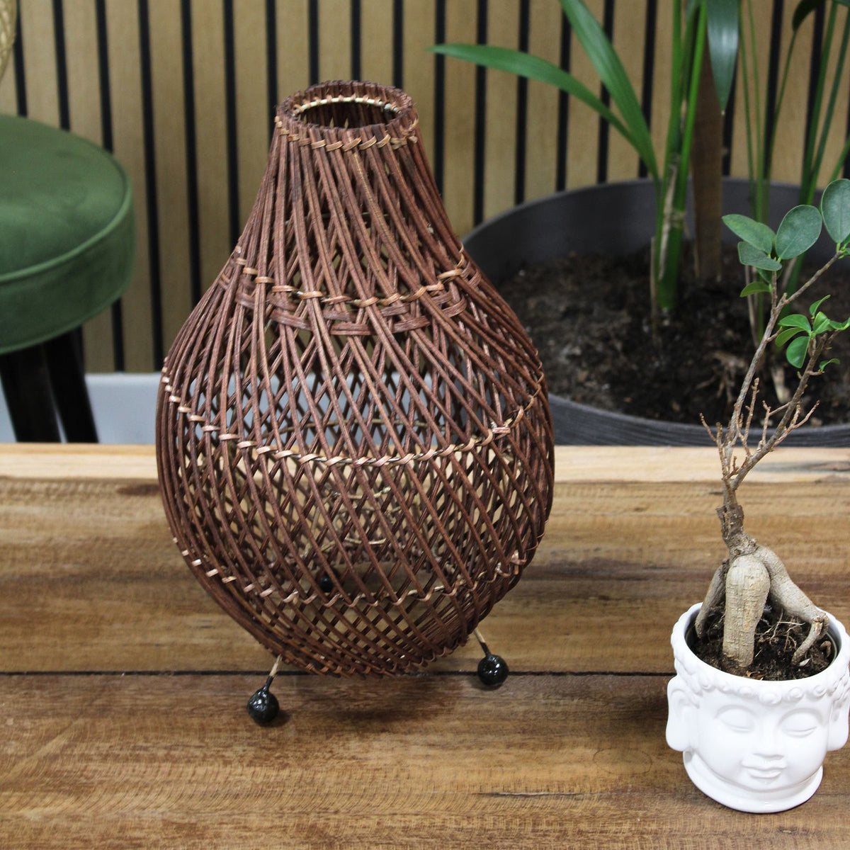 Dark brown rattan table lamp with teardrop woven shade and small round base feet