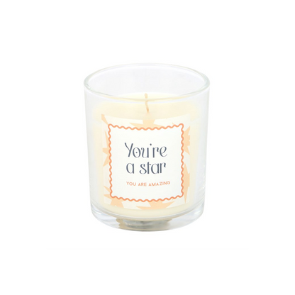Star-themed scented candle in clear glass jar with orange “You’re a star” label and wick