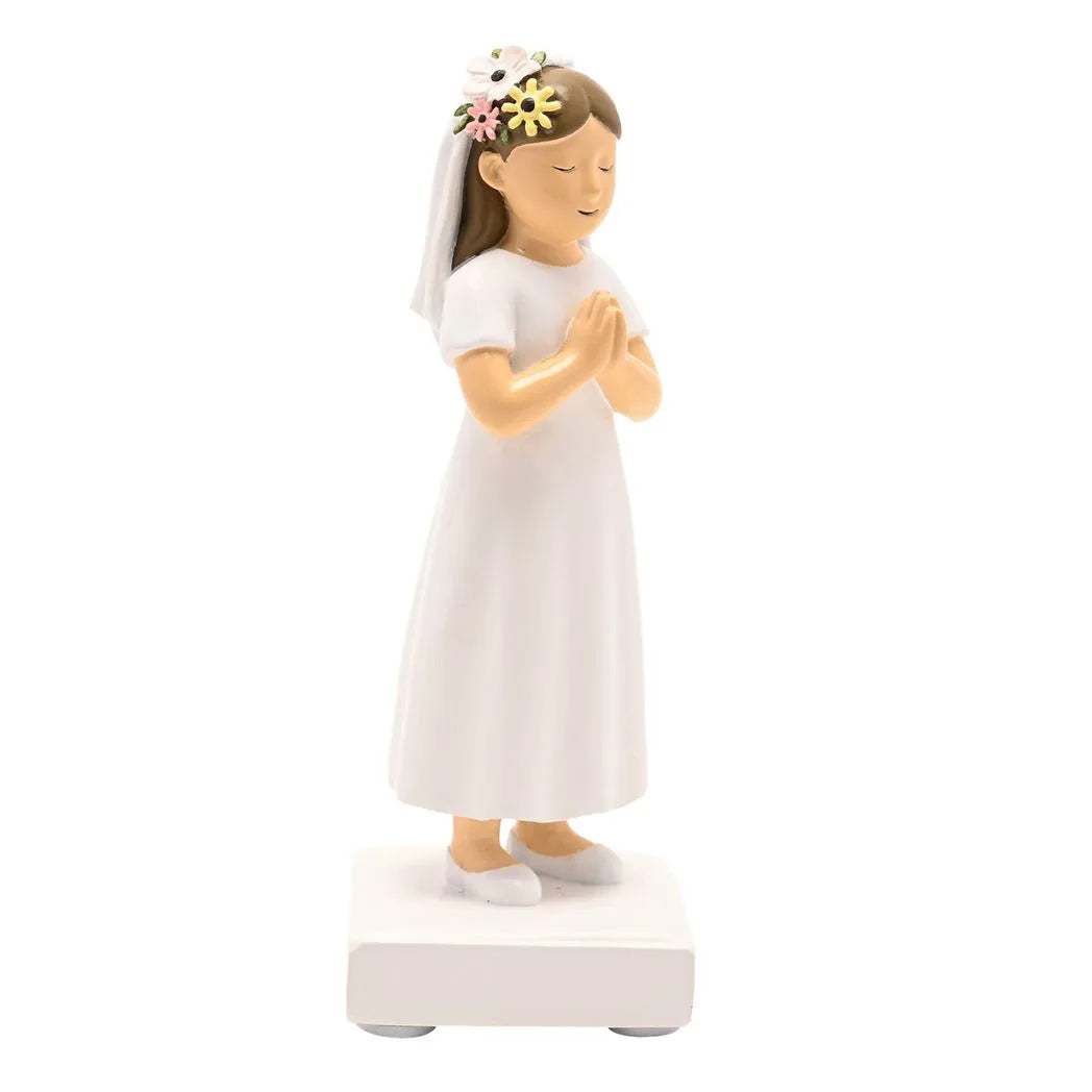Side view communion girl figurine in white dress with floral hair accessory, hands clasped