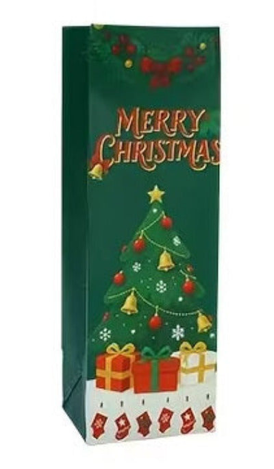 A dark green Christmas-themed gift bag featuring a decorated Christmas tree, wrapped presents, red stockings, and the words 'MERRY CHRISTMAS' in gold lettering.