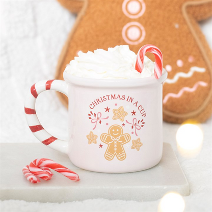 Pink ceramic mug with red candy-cane striped handle and gingerbread Christmas design