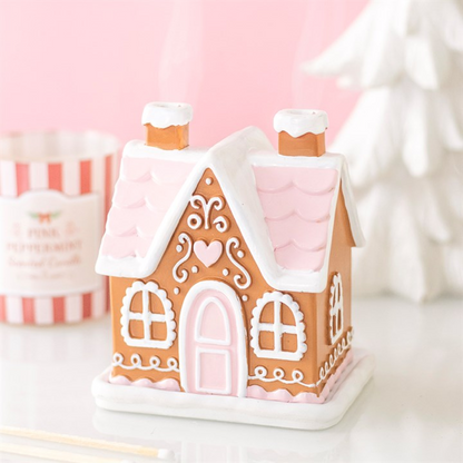 Pink gingerbread house incense cone burner with pink roof, white walls, arched door