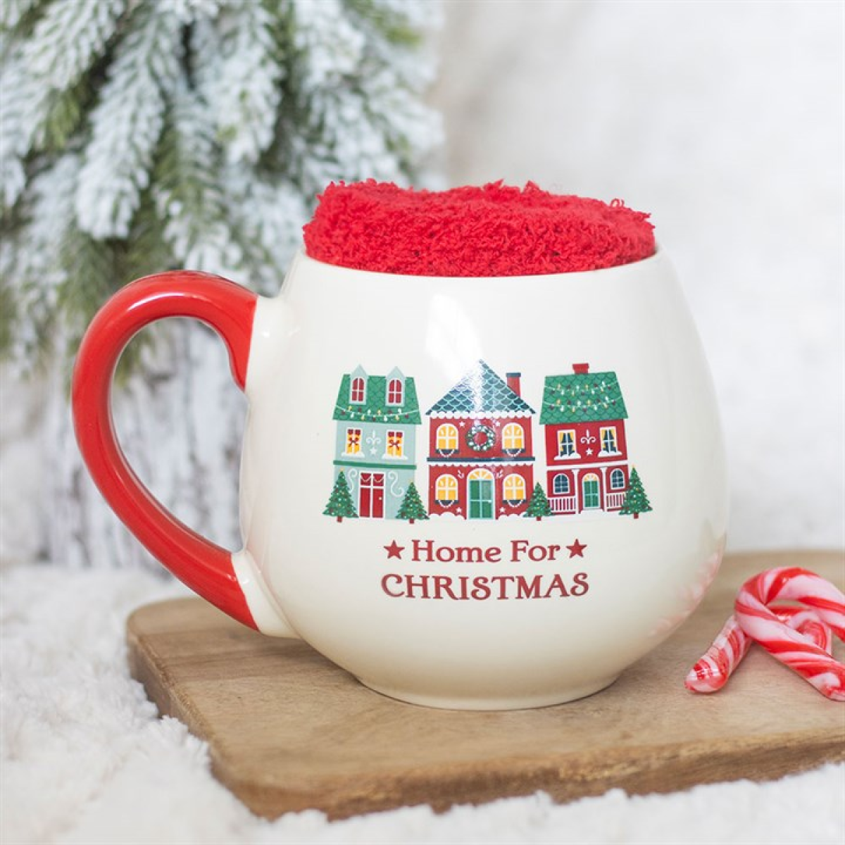 Christmas mug with red handle and fuzzy red topper, printed with houses and 'Home For Christmas'.