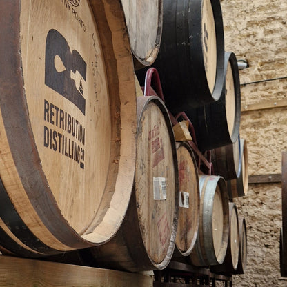 Stack of wooden distillery barrels on a metal rack