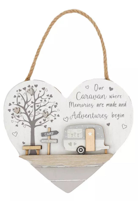 Heart-shaped wooden plaque with caravan illustration and text on a white background