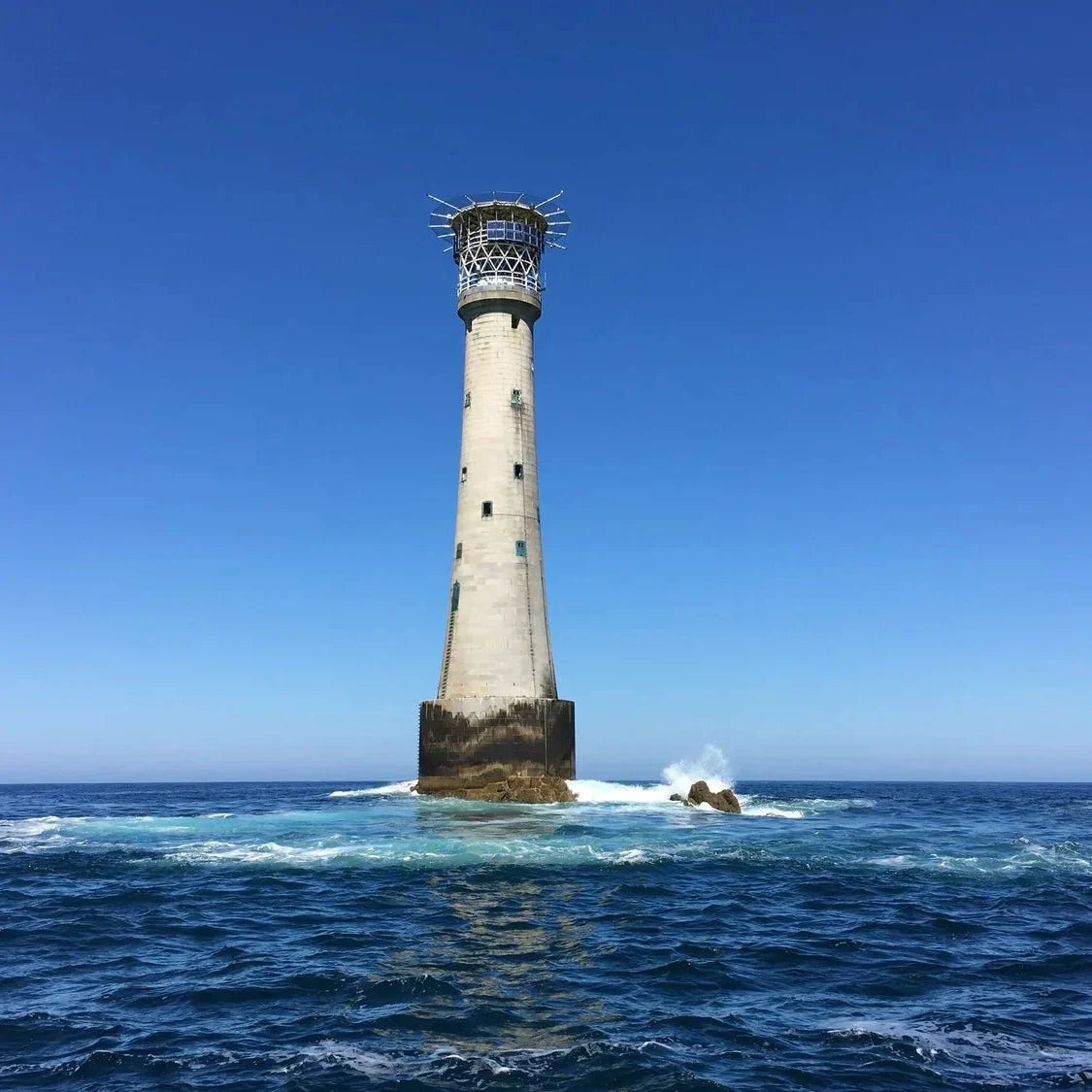 Island gin promotional lighthouse scene on a rocky coast with ocean waves