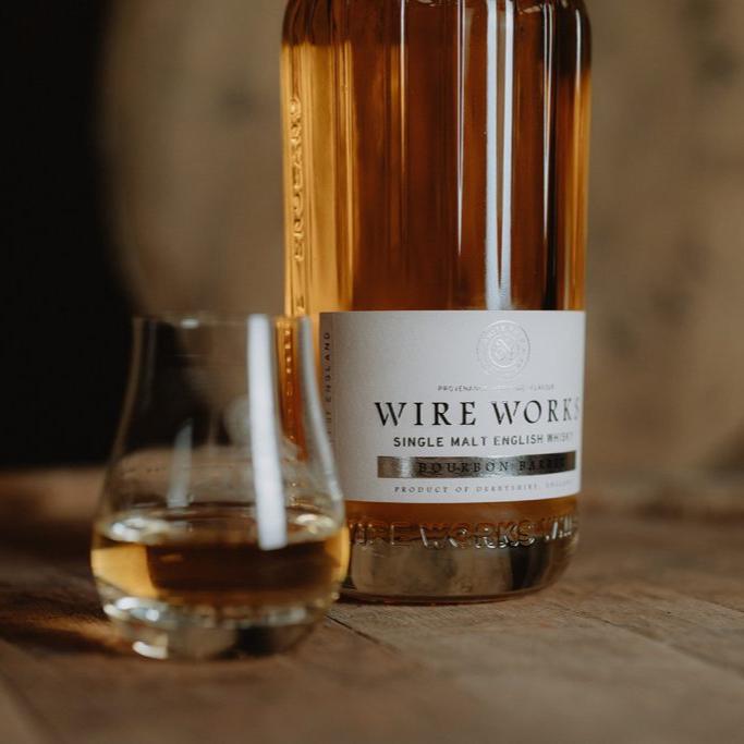 Single malt whisky bottle with two short glasses on a stone surface