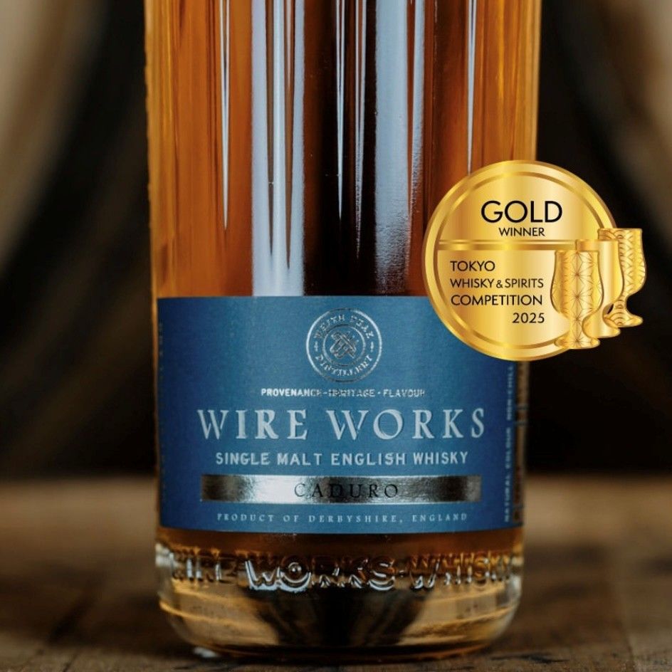 Amber whisky bottle with blue label and round Gold winner medal for Tokyo 2025