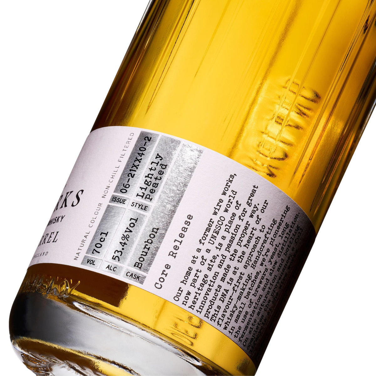 Bourbon barrel whisky bottle with white label and amber glass, close-up angle