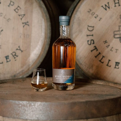 Wire Works single malt whisky bottle with two wooden casks and small spirit glass