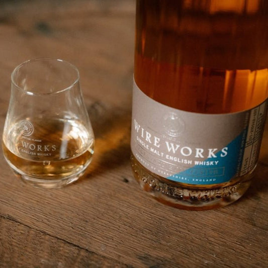 Wire Works whisky bottle base and tumbler glass with amber pour, partial label