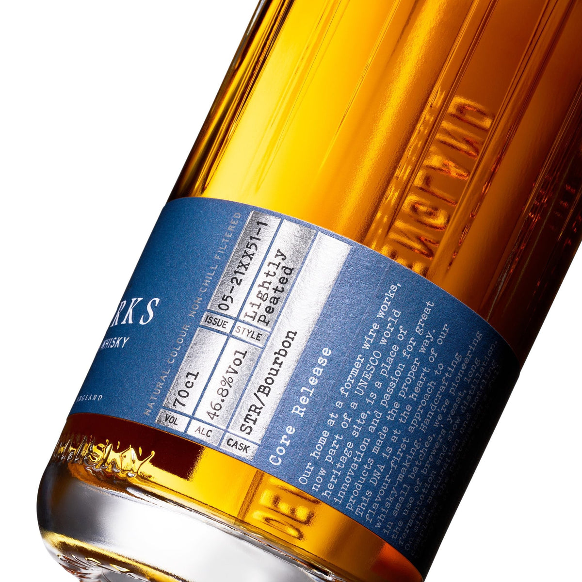 Amber whisky bottle close-up with blue label band and embossed bottle details